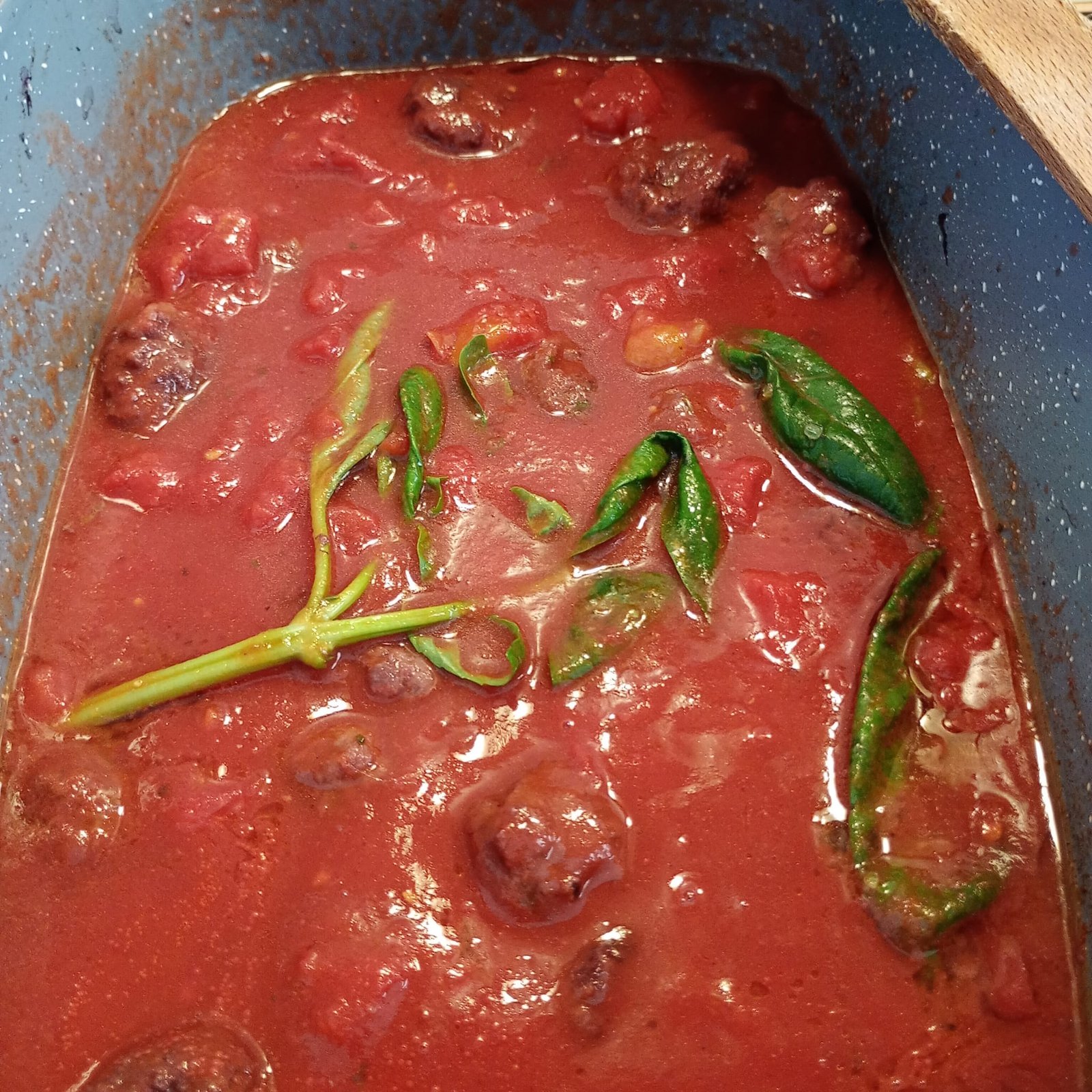 Sugo de tomate y albahaca cocinándose a fuego lento